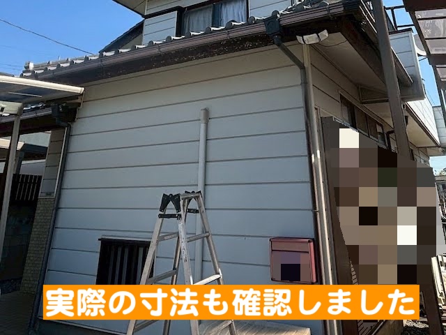 結城市　すすけた木製破風板への板金巻き工事　寸法取り作業の写真