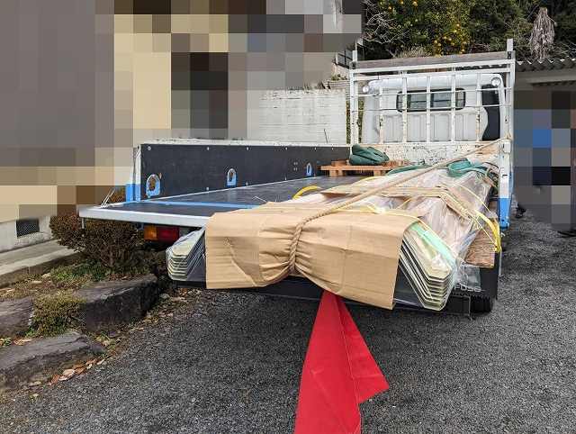 長さがある折板屋根なので赤旗をぶら下げてトラックで搬入