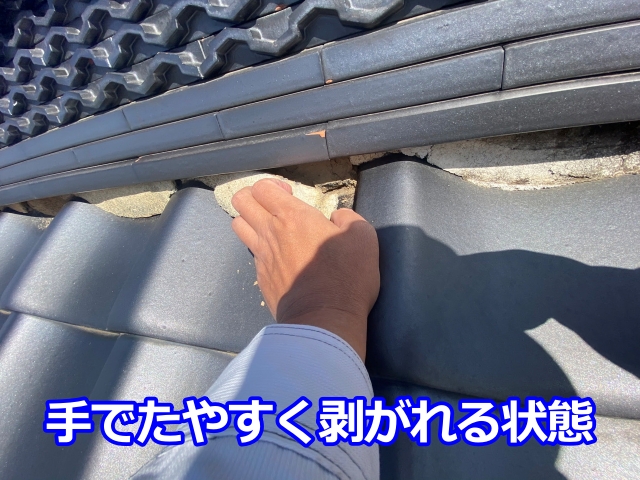 手でたやすく剥がれる状態の劣化した棟漆喰